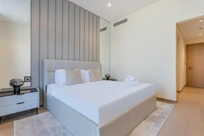 a bedroom with a large white bed in a room at Modern Comfort1BR RP Heights 5-min Dubai Mall in Dubai