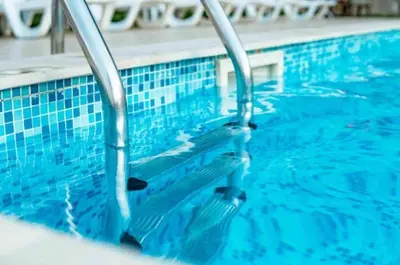 a swimming pool with blue tiles on the water at Stunning Apartment, Partial Sea View, Canal Marina View, 5 min walk To JBR Beach and METRO in Dubai