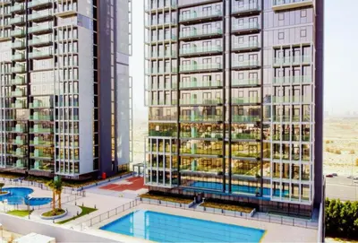 a view of two tall buildings with a swimming pool at Cosy Studio Apartment in Bloom Towers, Jumeirah Village Circle in Dubai