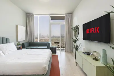 a hotel room with a bed and a television at Cosy Studio Apartment in Bloom Towers, Jumeirah Village Circle in Dubai