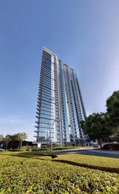 a tall building with a park in front of it at Apartment 1015 Waves in Dubai