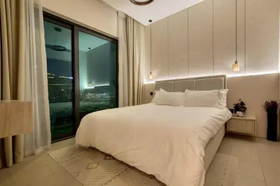 a bedroom with a large bed and a large window at Apartment 1015 Waves in Dubai