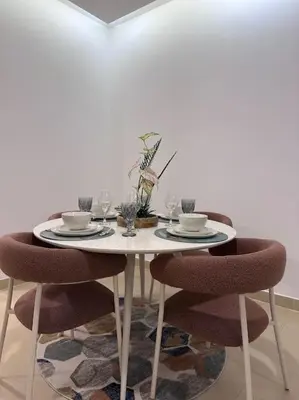 a dining room table with two chairs and glasses on it at Luxury sea-view apartment in Dubai