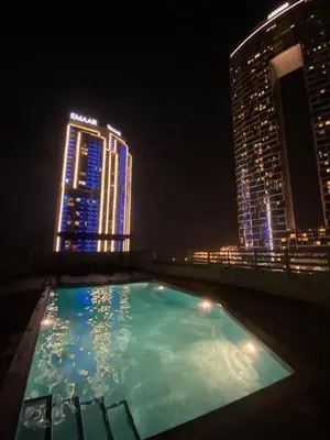 a swimming pool on the roof of a building at night at Luxury sea-view apartment in Dubai