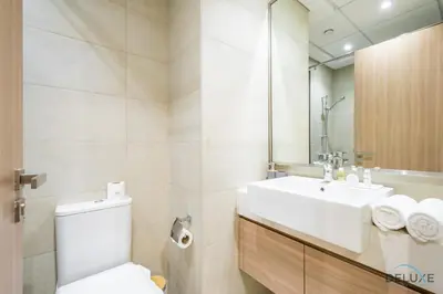 a bathroom with a toilet and a sink and a mirror at Charming Studio at Azizi Riviera 32, Al Merkadh by Deluxe Holiday Homes in Dubai