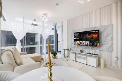 a living room with a couch and a flat screen tv at Luxury Apt Burj Khalifa, Sunset and Lagoon view in Dubai