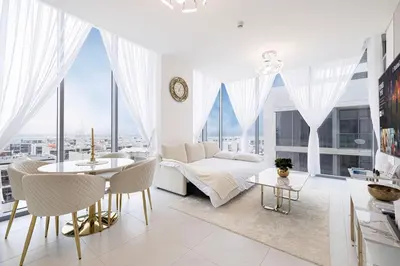 a white room with a bed and a table and chairs at Luxury Apt Burj Khalifa, Sunset and Lagoon view in Dubai