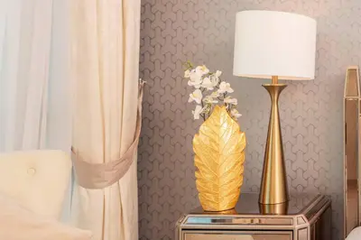 a table with a lamp and a vase with flowers on it at Elite Royal Apartment - Sky Series - Breathtaking View - Full Burj Khalifa & Fountain in Dubai