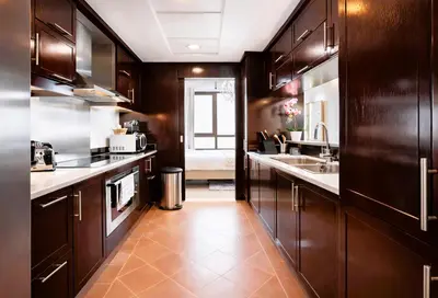 a kitchen with dark wood cabinets and a sink and a counter at Elite Royal Apartment - Sky Series - Breathtaking View - Full Burj Khalifa & Fountain in Dubai