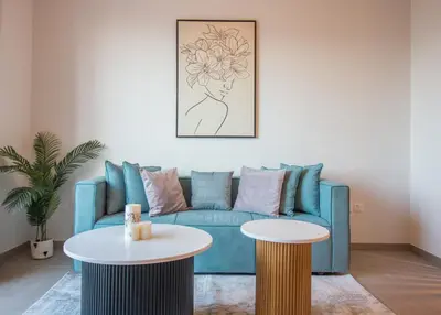 a living room with a blue couch and two tables at Offer! 1BR, Skyline View, Dubai Hills Estate, Park Ridge in Dubai