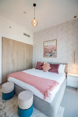 a bedroom with a large bed with two ottomans at Offer! 1BR, Skyline View, Dubai Hills Estate, Park Ridge in Dubai
