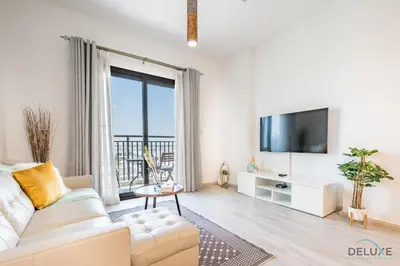 a living room with a white couch and a tv at Delightful 2BR Apartment in Town Square Safi 1A, Dubailand by Deluxe Holiday Homes in Dubai