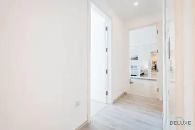 a hallway with white walls and a large mirror at Delightful 2BR Apartment in Town Square Safi 1A, Dubailand by Deluxe Holiday Homes in Dubai