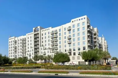 a large white building with trees in front of it at Delightful 2BR Apartment in Town Square Safi 1A, Dubailand by Deluxe Holiday Homes in Dubai