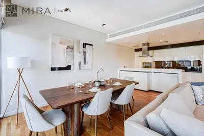a living room with a wooden table and a couch at Mira Holiday Homes - Luxury 2 bedroom in Bluewaters with stunning view in Dubai