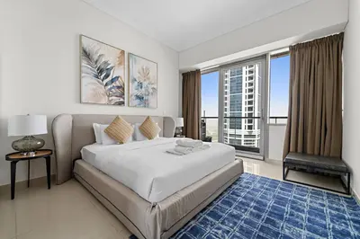 a bedroom with a large bed and a large window at StoneTree - High Floor - Prime location in Dubai
