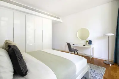 a bedroom with a bed and a desk and a mirror at Frank Porter - Bluewaters Residences Building 5 in Dubai