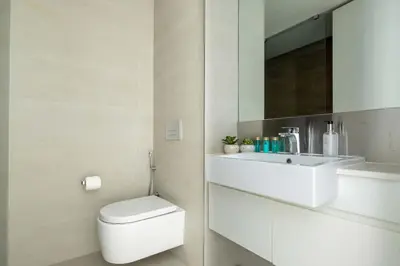 a white bathroom with a toilet and a sink at Frank Porter - Bluewaters Residences Building 5 in Dubai