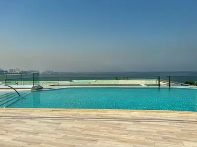 a large swimming pool with a view of the ocean at Frank Porter - Bluewaters Residences Building 5 in Dubai