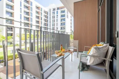 a balcony with chairs and a table and a building at Frank Porter - Park Point Building C in Dubai