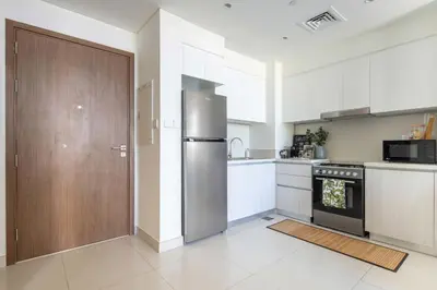 a kitchen with a refrigerator and a wooden door at Frank Porter - Park Point Building C in Dubai