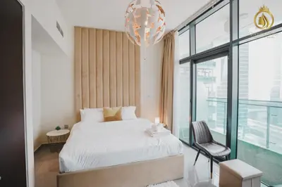 a bedroom with a bed and a chandelier at Queens Estate Vacation Homes - Merano Tower, Business Bay in Dubai