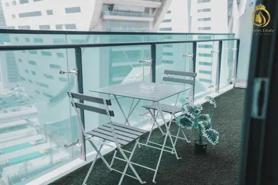 a glass table and two chairs on a balcony at Queens Estate Vacation Homes - Merano Tower, Business Bay in Dubai
