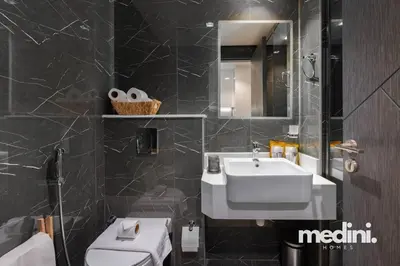 a bathroom with a sink and a toilet and a mirror at Studio in Samana Golf Avenue - Dubai in Dubai