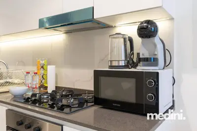 a microwave sitting on top of a kitchen counter at Studio in Samana Golf Avenue - Dubai in Dubai