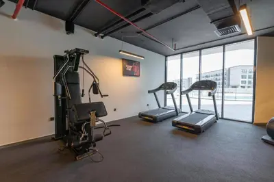 a gym with treadmills and ellipticals in a room at Studio in Samana Golf Avenue - Dubai in Dubai