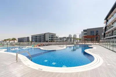 a large swimming pool in the middle of a building at Studio in Samana Golf Avenue - Dubai in Dubai