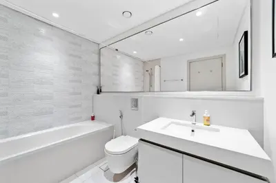 a bathroom with a sink and a toilet and a mirror at Spacious 2 BHK next to the Beach - Sunrise Bay in Dubai