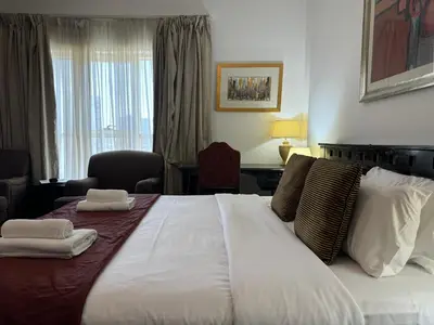 a hotel room with a large bed with towels on it at ASHRI HH, Studio in JVC Dana Tower in Dubai