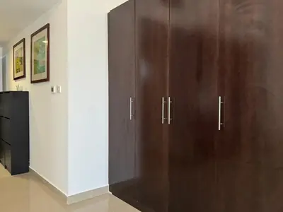 a large wooden cabinet in a living room at ASHRI HH, Studio in JVC Dana Tower in Dubai