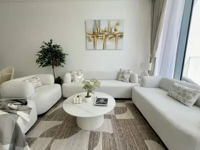a living room with white couches and a table at Spacious 1bedroom W Lagoon In Al Maktoum City in Dubai