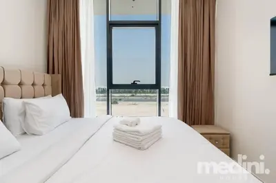 a bedroom with a large white bed with a window at 2 bhk with Private Pool - Samana Golf Avenue - Dubai in Dubai
