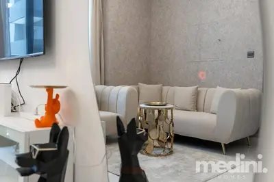 a living room with a white couch and a table at 2 bhk with Private Pool - Samana Golf Avenue - Dubai in Dubai