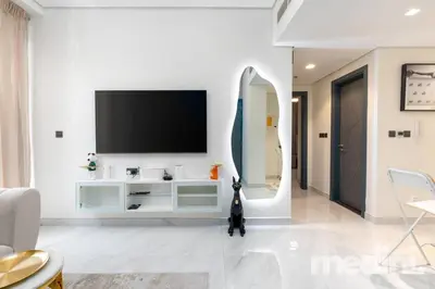 a living room with a tv on a white wall at 2 bhk with Private Pool - Samana Golf Avenue - Dubai in Dubai