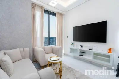 a living room with white furniture and a flat screen tv at 2 bhk with Private Pool - Samana Golf Avenue - Dubai in Dubai