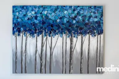 a painting of trees with blue flowers at Oxford Boulevard - Studio - JVC Dubai in Dubai