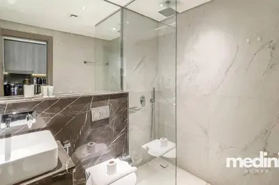 a bathroom with a shower and a sink and a toilet at Oxford Boulevard - Studio - JVC Dubai in Dubai