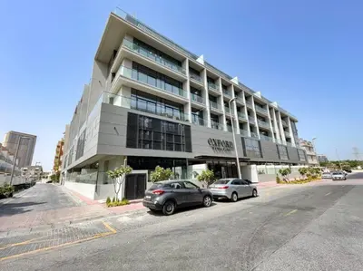 a building with two cars parked in front of it at Oxford Boulevard - Studio - JVC Dubai in Dubai