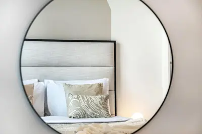 a mirror reflection of a bed with pillows at The Smarft Concierge - Sobha Creek Vista in Dubai