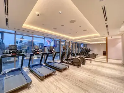 a gym with a row of treadmills and elliptical machines at The Smarft Concierge - Sobha Creek Vista in Dubai