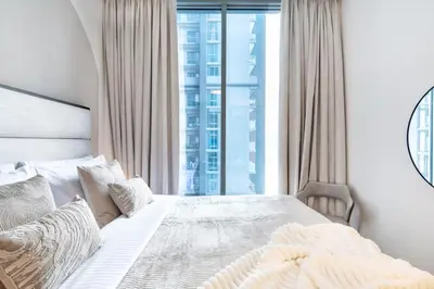 a bedroom with a white bed with a large window at The Smarft Concierge - Sobha Creek Vista in Dubai