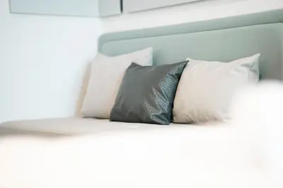 a bed with three pillows on it at AWS Holiday Homes - Chic Downtown Views in Dubai