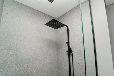 a shower with a shower head in a bathroom at AWS Holiday Homes - Chic Downtown Views in Dubai