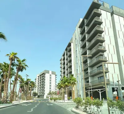 an empty street in front of a building with palm trees at AWS Holiday Homes - Chic Downtown Views in Dubai