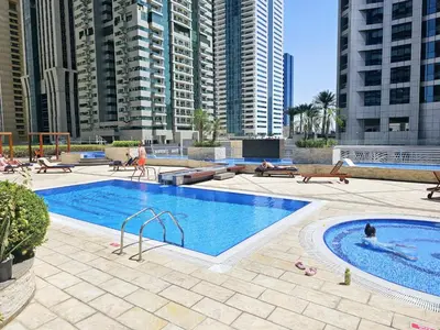 a large swimming pool in a city with tall buildings at Spacious 1-BR close to Barasti Beach and Marina Walk in Dubai