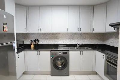 a kitchen with a washing machine and a sink at Spacious 1-BR close to Barasti Beach and Marina Walk in Dubai